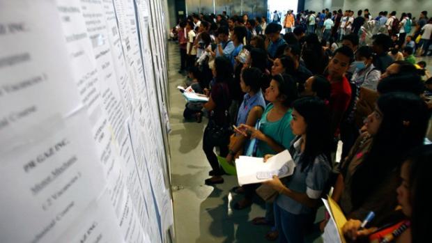 Applicants look at the list of jobs at the Labor Day Job Fair by the Department of Labor and Employment at the SMX Convention Center in Pasay City on May 1, 2014. A government think tank on Tuesday, Sept. 9, 2014, urged policymakers to relax wage regulations and allow small and medium businesses to pay salaries below the minimum wage when they hire unskilled workers. INQUIRER PHOTO/RAFFY LERMA